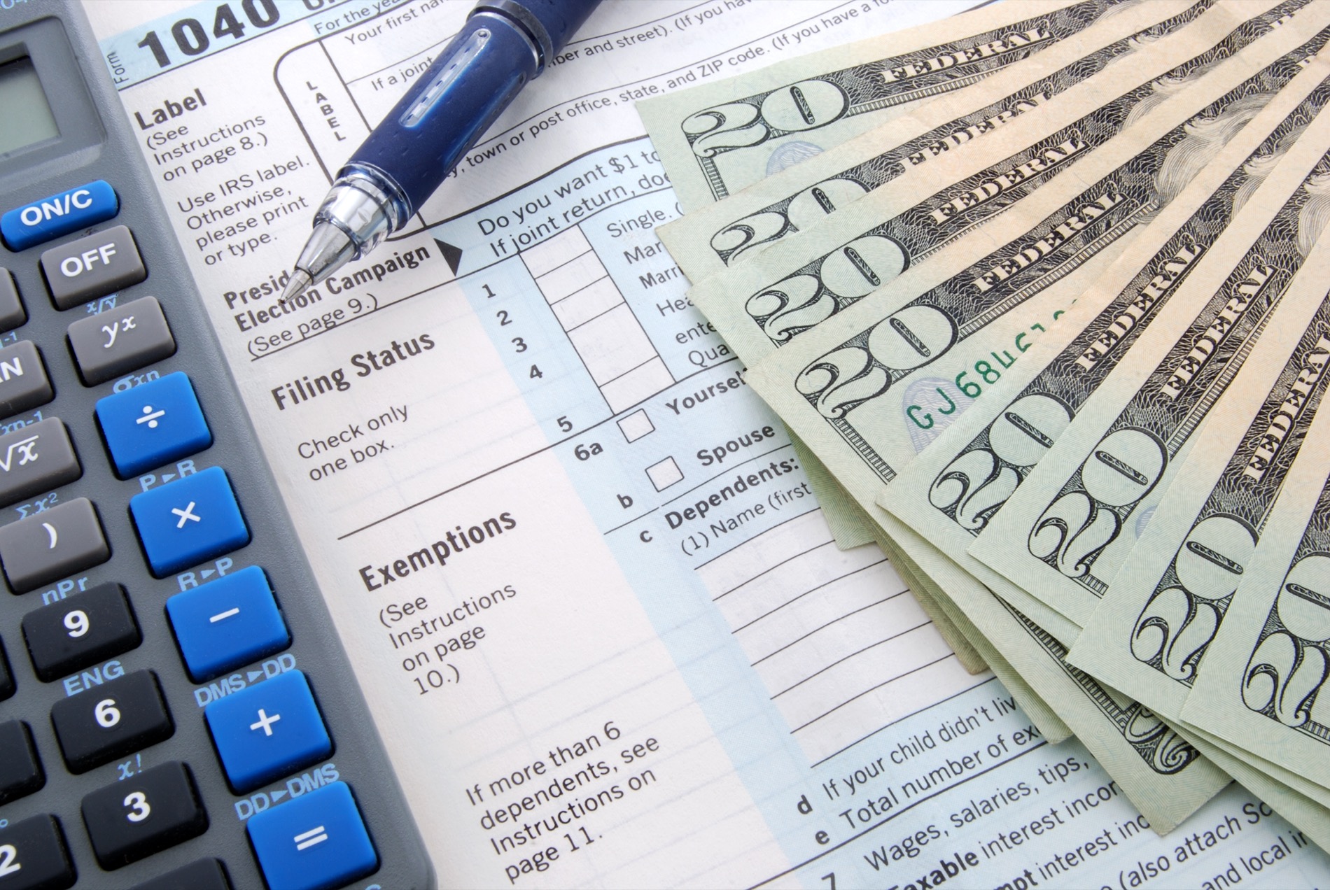 Planning for your retirement taxes can save you money. A calculator sits next to tax forms and a stack of twenty-dollar bills.