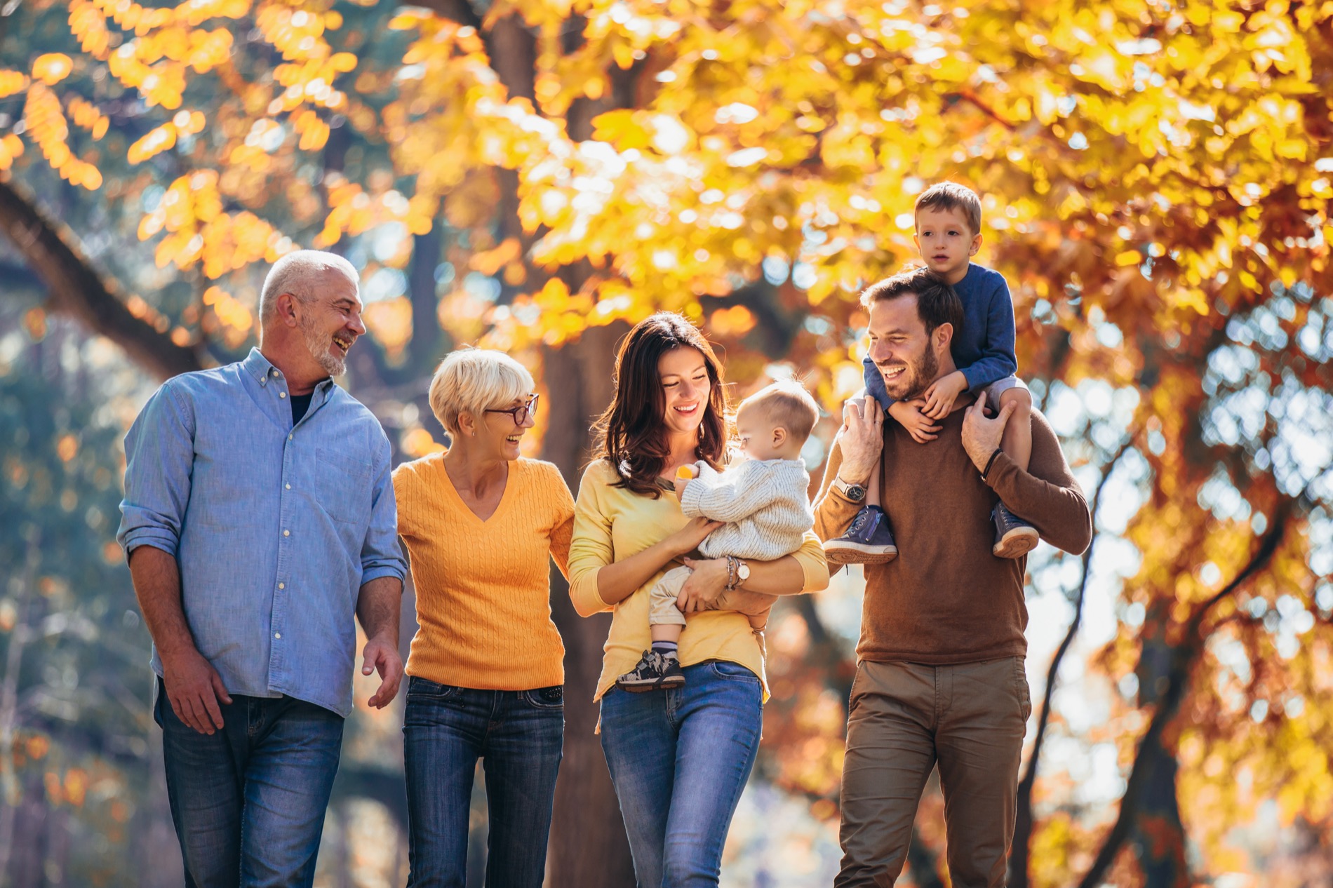 Multi-generational family walking together in the park in autumn.