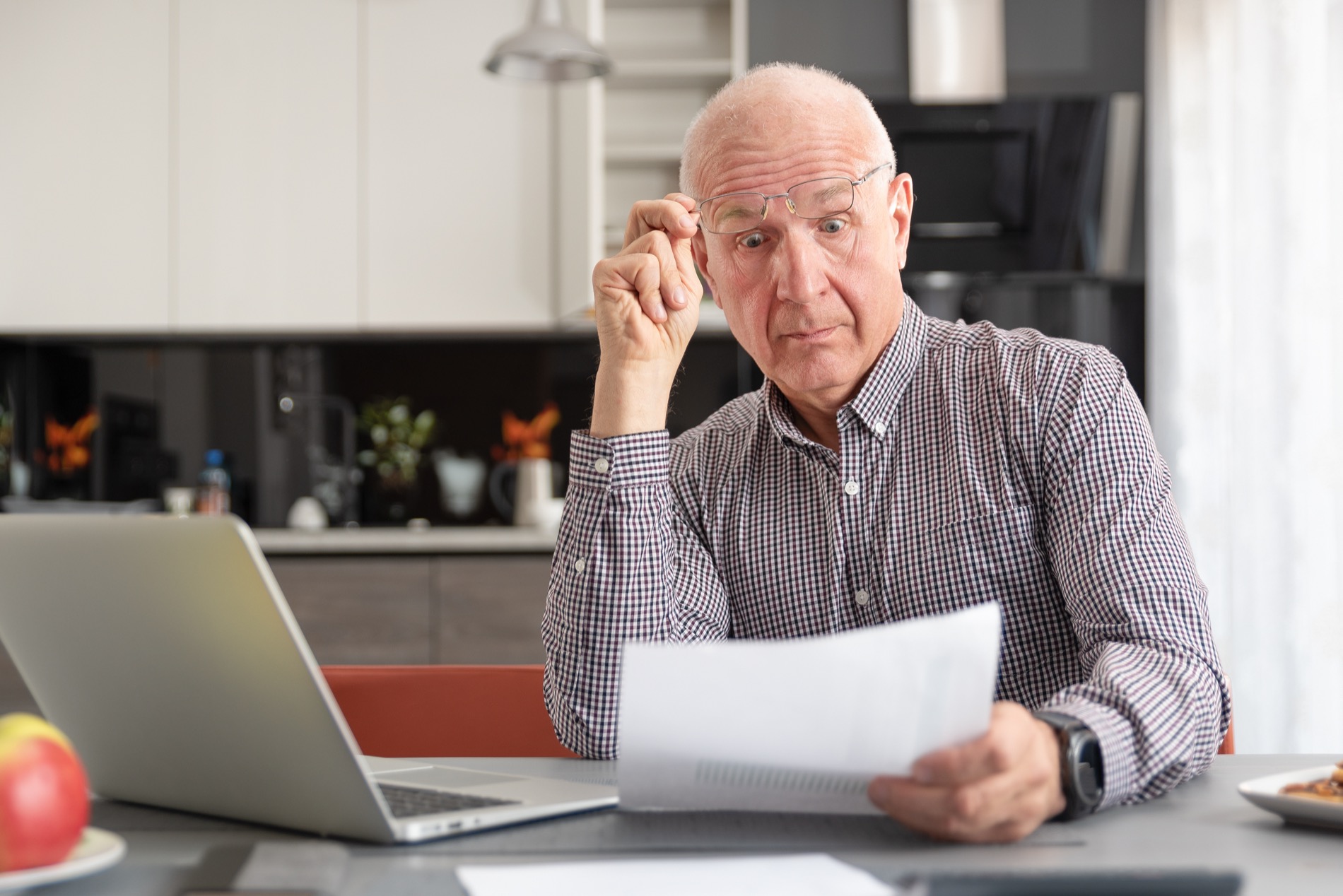 Senior man at his laptop, worried about his retirement income and savings.