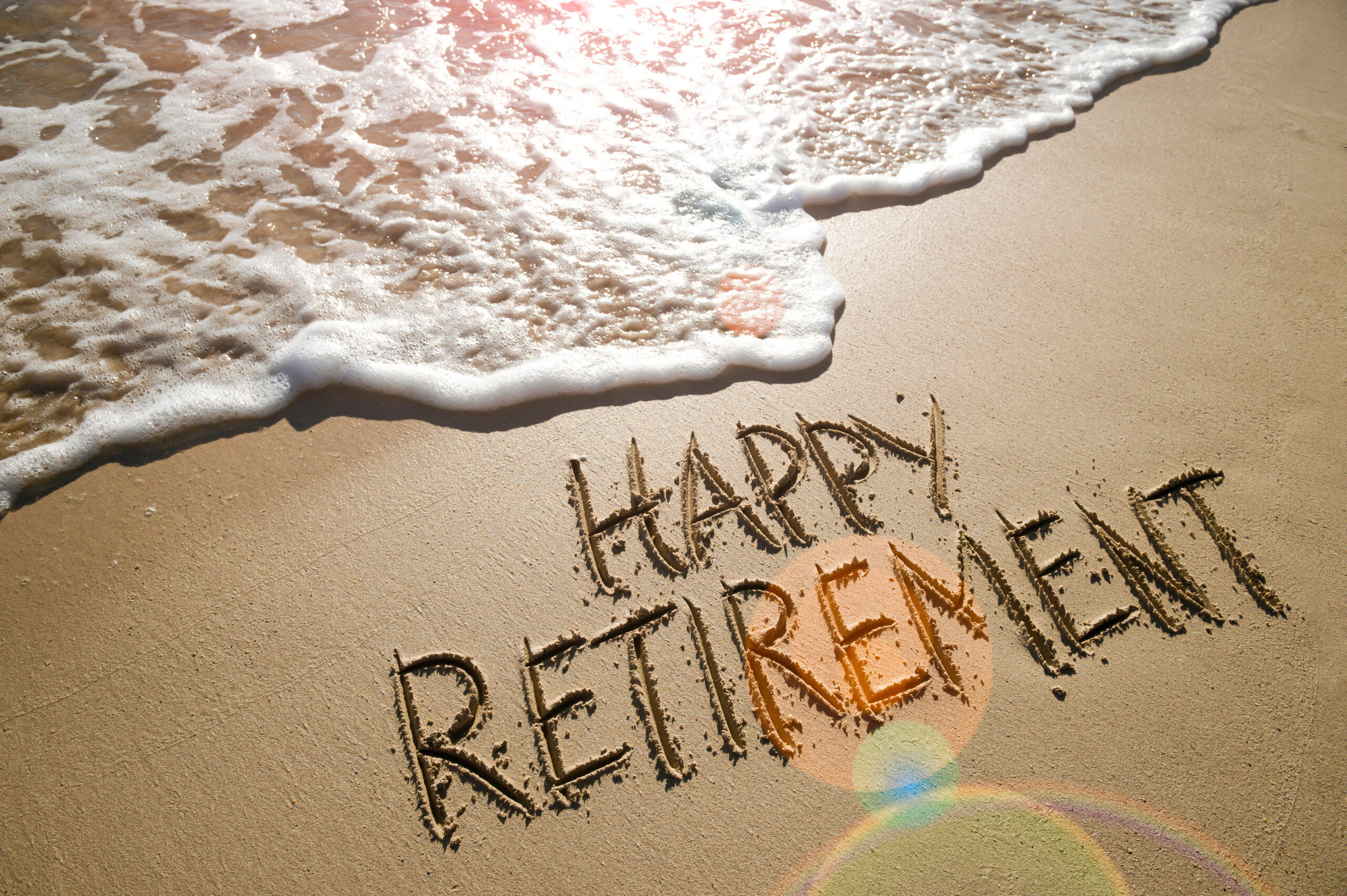First retirement check and what to expect in retirement. Happy Retirement written on the beach